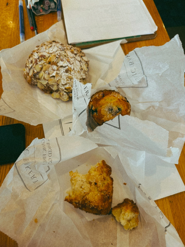 An almond croissant, scone and blueberry muffin from Rustic Bakery in Marin County with a notebook and pens.
